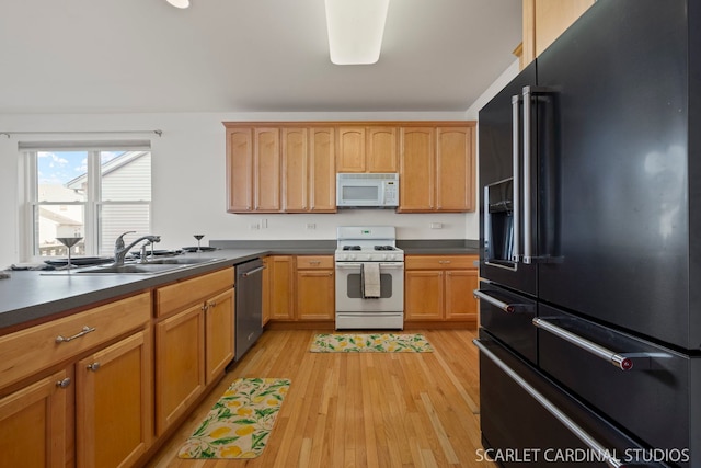 kitchen with sink, white appliances, and light hardwood / wood-style flooring