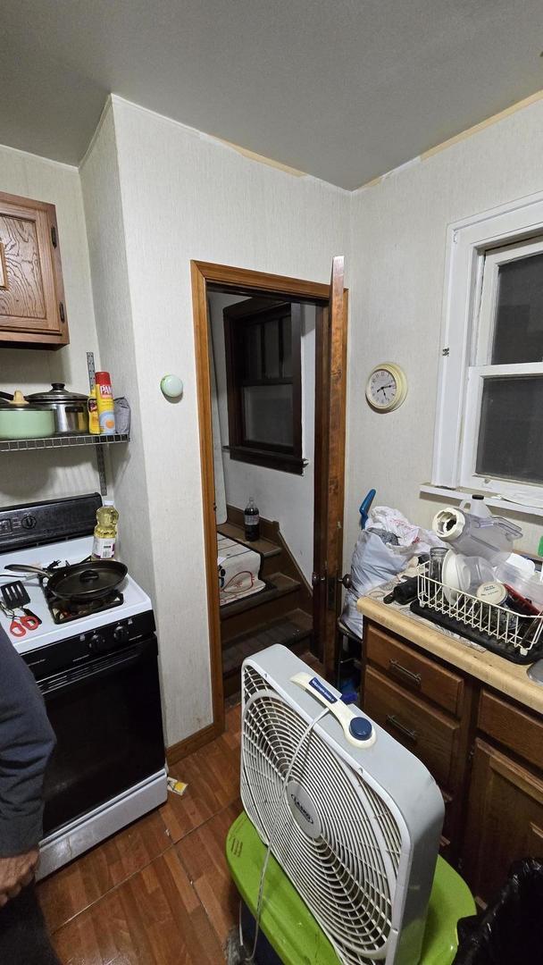 kitchen featuring white gas stove and dark wood-type flooring