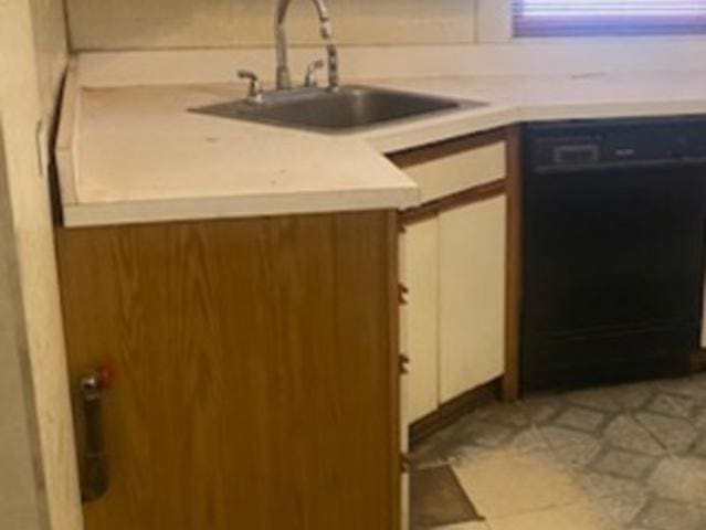 kitchen featuring sink, white cabinetry, and black dishwasher