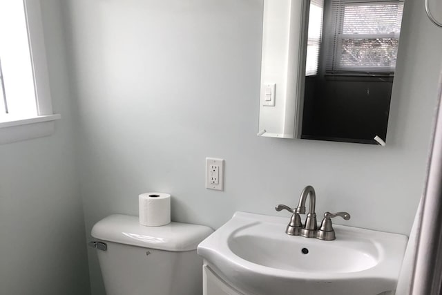 bathroom with plenty of natural light, toilet, and vanity