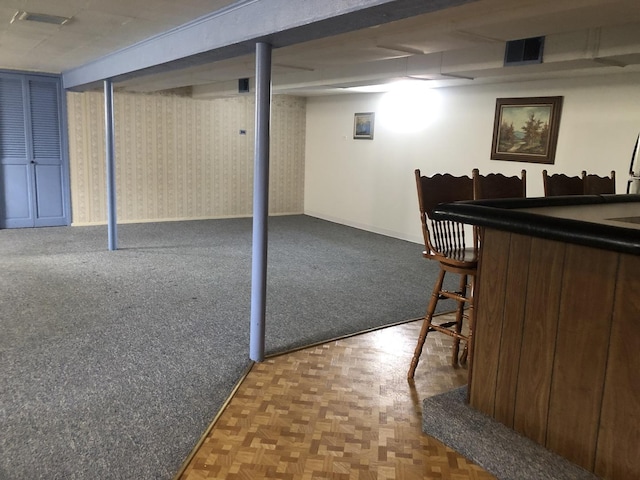 basement with parquet floors and bar