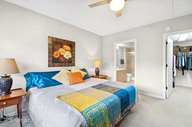 carpeted bedroom featuring a walk in closet, ceiling fan, a closet, and ensuite bathroom