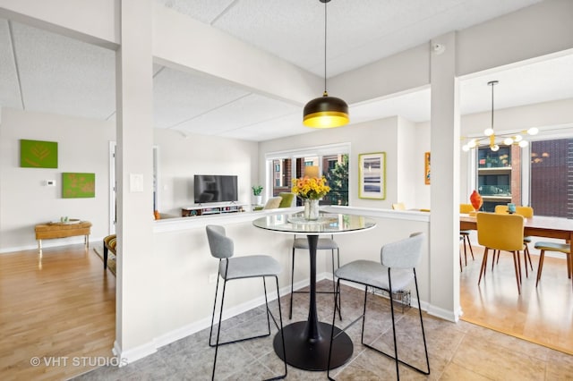 kitchen with pendant lighting, kitchen peninsula, and light tile patterned floors