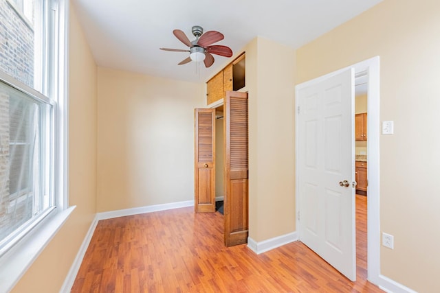 spare room featuring light hardwood / wood-style flooring, ceiling fan, and a healthy amount of sunlight