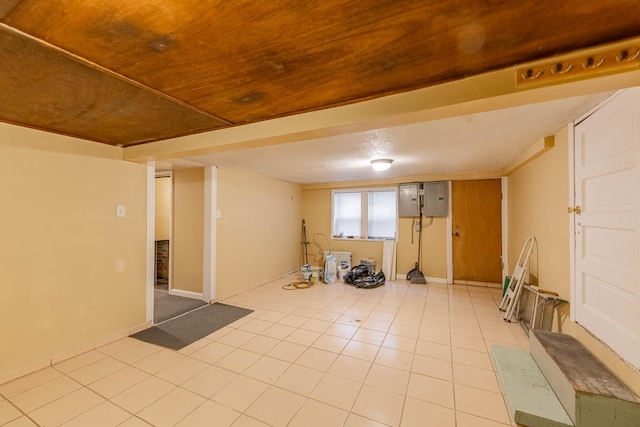 basement featuring light tile patterned floors, electric panel, and wood ceiling