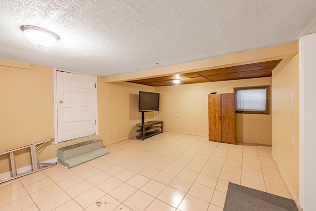 basement with a textured ceiling and light tile patterned flooring