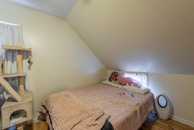 bedroom featuring lofted ceiling and light wood-type flooring