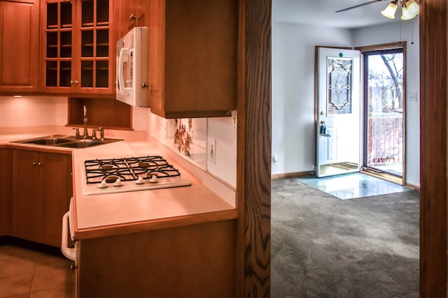 kitchen with ceiling fan, sink, white appliances, and dark colored carpet