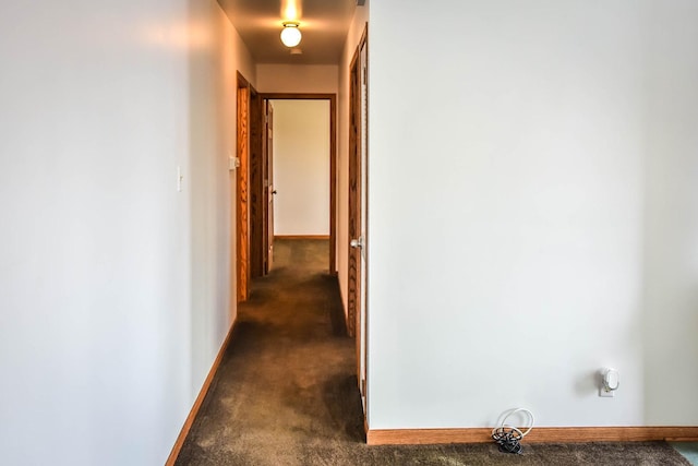 hall with dark colored carpet