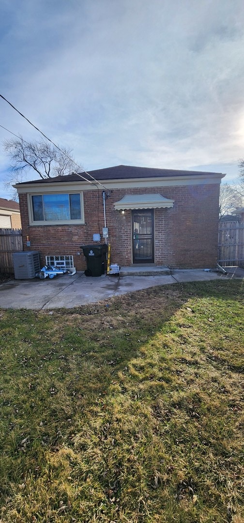 back of property featuring central AC, a patio area, and a lawn