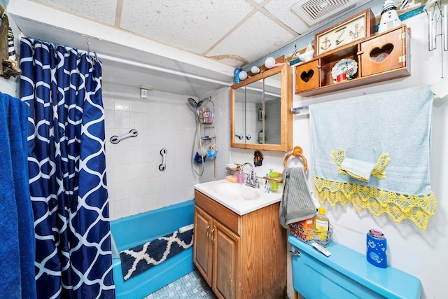 bathroom with a drop ceiling, vanity, and shower / tub combo with curtain