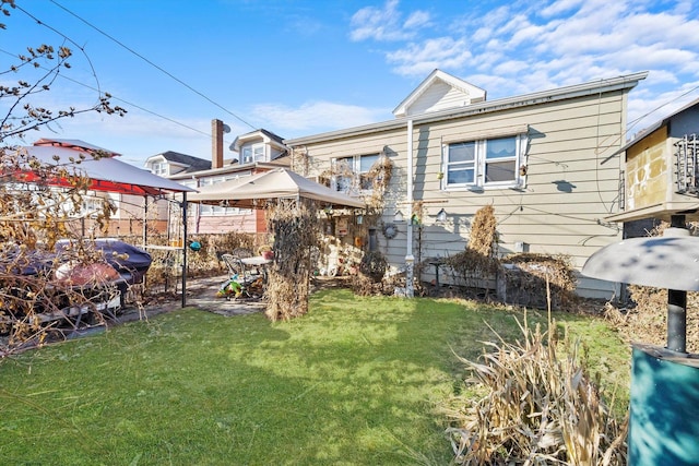 rear view of property featuring a yard