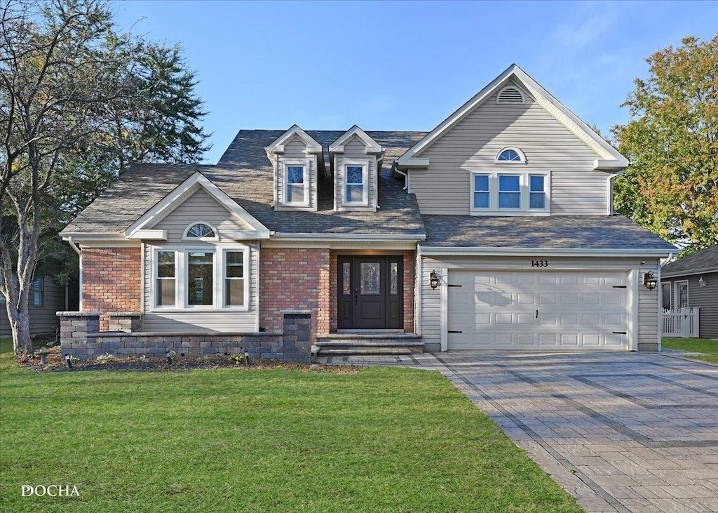 view of front of home with a garage and a front lawn