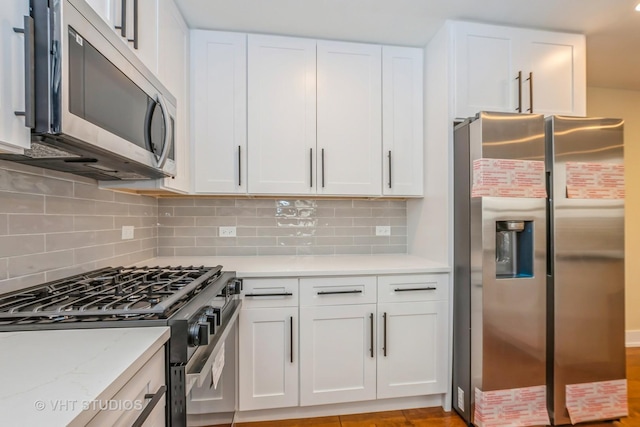 kitchen featuring decorative backsplash, white cabinetry, and stainless steel appliances