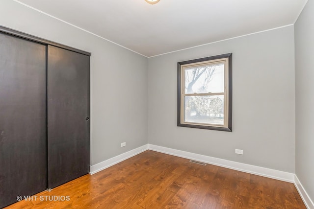 unfurnished bedroom with a closet and hardwood / wood-style floors