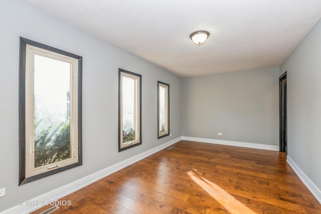 unfurnished room with dark wood-type flooring