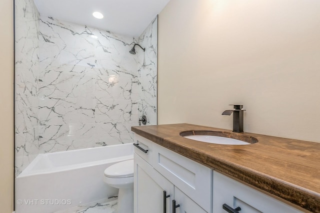 full bathroom featuring toilet, vanity, and tiled shower / bath combo