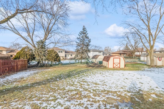 yard layered in snow featuring a storage shed