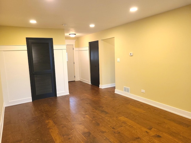 empty room with dark hardwood / wood-style flooring