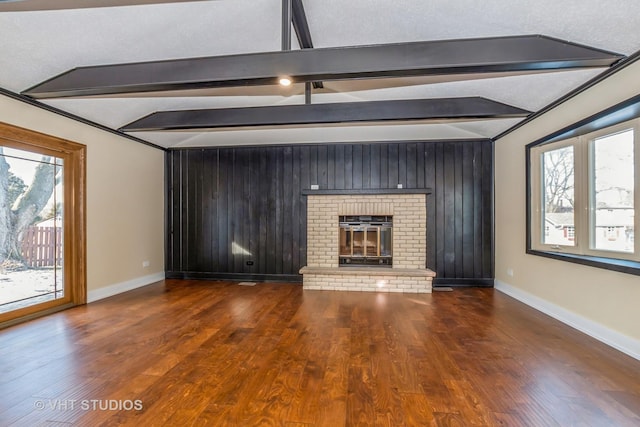 unfurnished living room featuring a brick fireplace, vaulted ceiling with beams, dark hardwood / wood-style flooring, and a textured ceiling