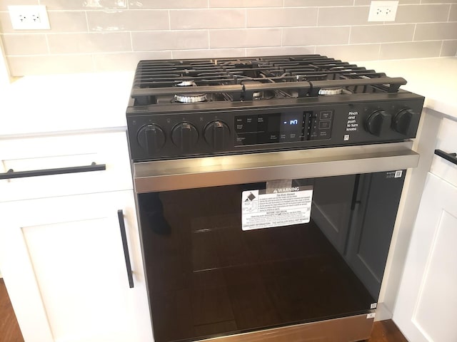 room details featuring decorative backsplash and range with gas stovetop