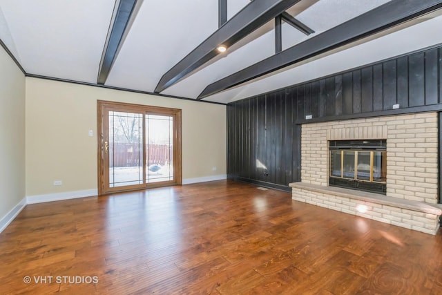 unfurnished living room featuring hardwood / wood-style floors, vaulted ceiling with beams, and a fireplace