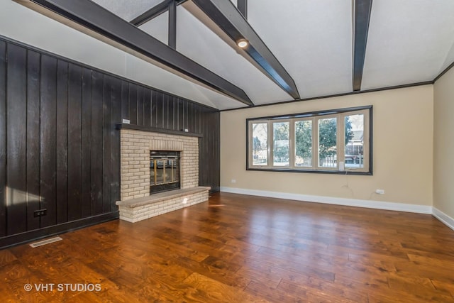 unfurnished living room featuring a brick fireplace, wood-type flooring, and vaulted ceiling with beams