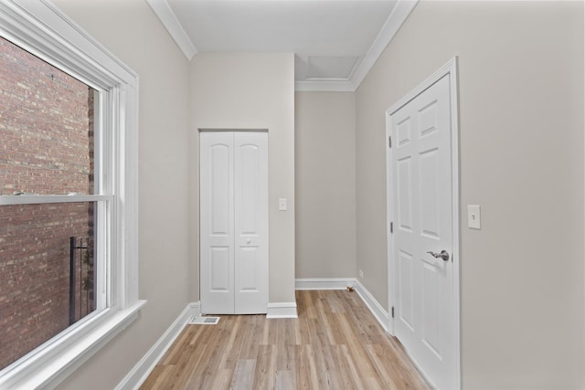 hallway featuring light wood-type flooring and crown molding