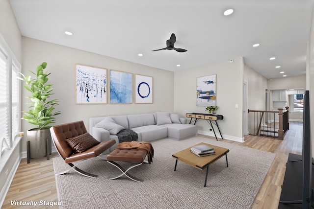 living room with ceiling fan and light hardwood / wood-style flooring