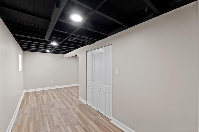 basement with light hardwood / wood-style flooring