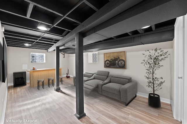 basement featuring beverage cooler and hardwood / wood-style flooring