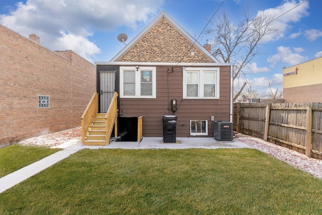 back of property featuring central AC unit and a lawn