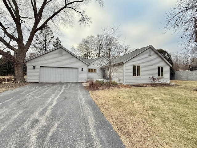 ranch-style home featuring a garage and a front lawn