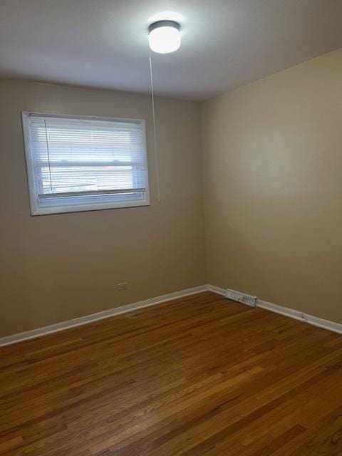 empty room with hardwood / wood-style flooring