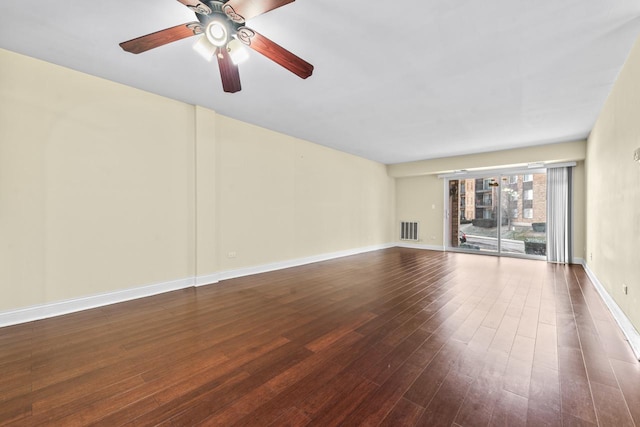 unfurnished living room featuring dark wood-type flooring and ceiling fan