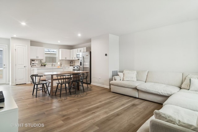 living room with light hardwood / wood-style floors and sink