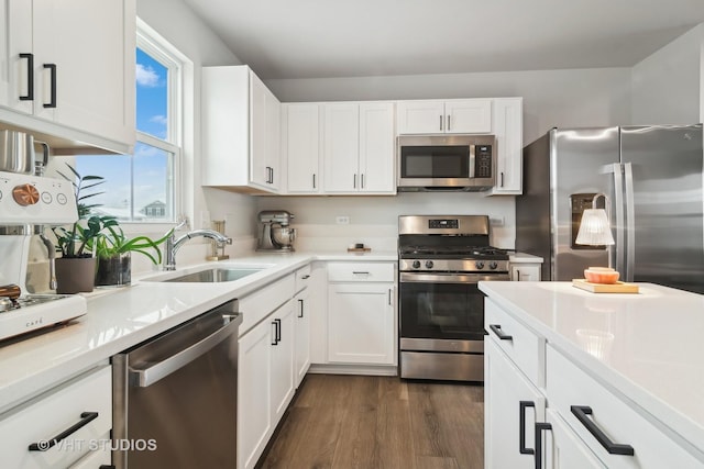 kitchen with stainless steel appliances, white cabinetry, dark hardwood / wood-style flooring, and sink