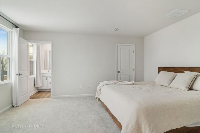 carpeted bedroom featuring ensuite bathroom