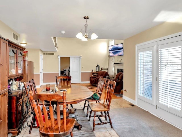 dining area featuring light tile patterned floors and a notable chandelier