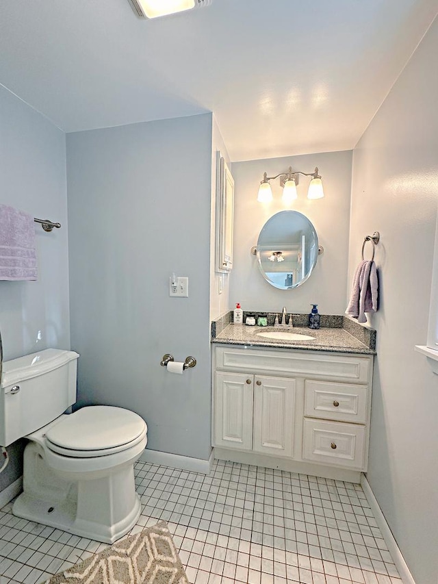 bathroom with tile patterned flooring, vanity, and toilet