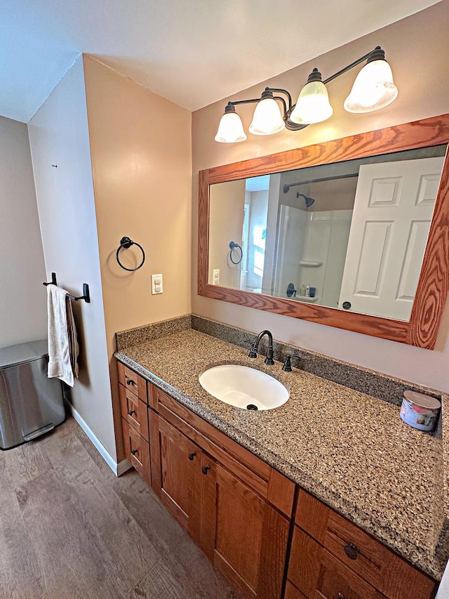 bathroom featuring hardwood / wood-style floors, vanity, and walk in shower