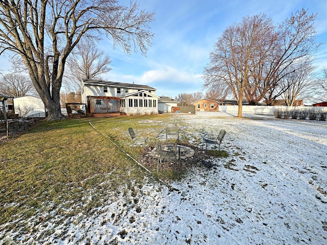 yard layered in snow with a sunroom