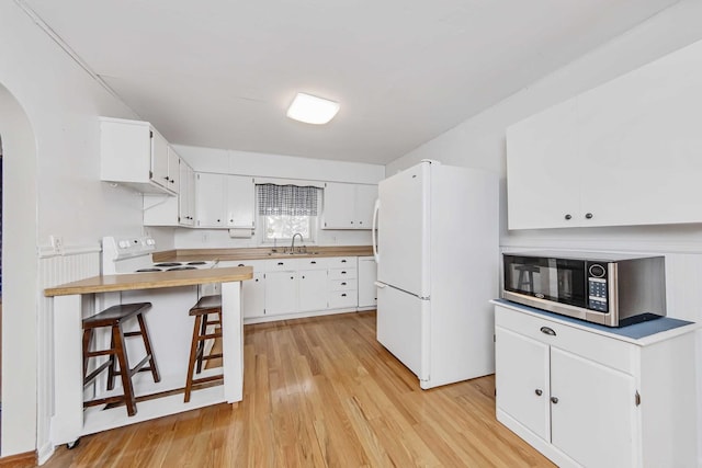 kitchen with wooden counters, white appliances, white cabinets, light hardwood / wood-style flooring, and sink