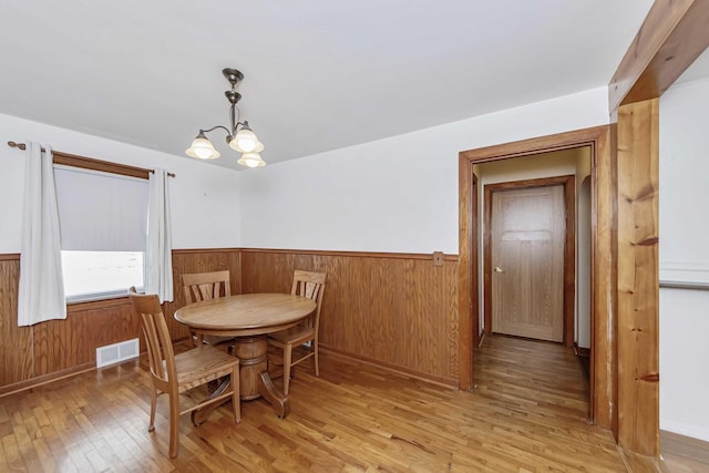 dining area with an inviting chandelier and light hardwood / wood-style flooring
