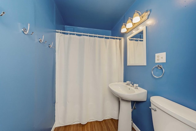 bathroom with toilet, sink, and hardwood / wood-style flooring
