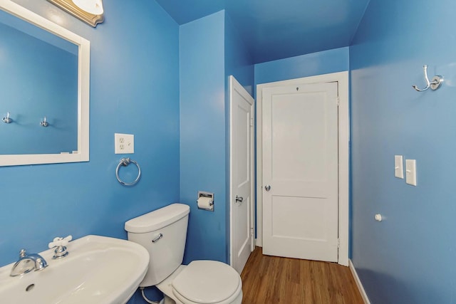 bathroom featuring toilet, sink, and hardwood / wood-style flooring