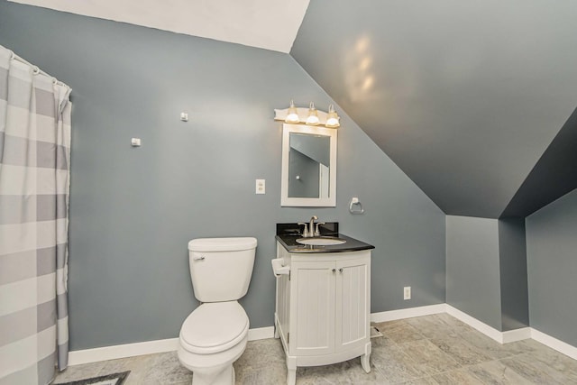 bathroom with vaulted ceiling, toilet, and vanity