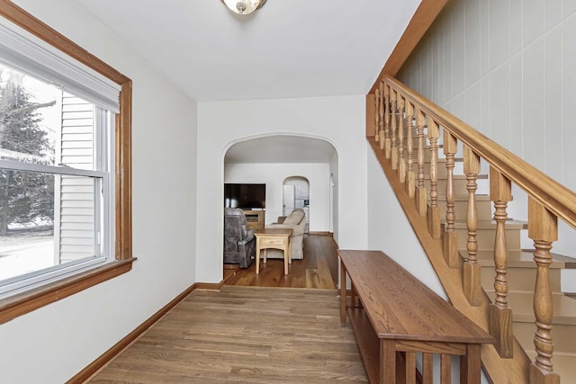 hall with a healthy amount of sunlight and wood-type flooring