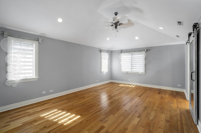 unfurnished room featuring hardwood / wood-style flooring, vaulted ceiling, and ceiling fan