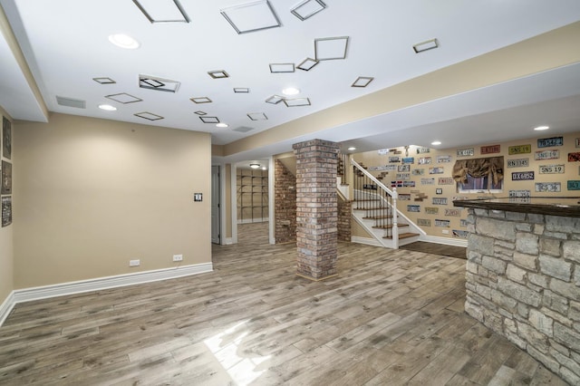 interior space with hardwood / wood-style floors, ornate columns, and bar